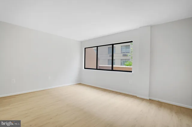 an empty room with windows and closet