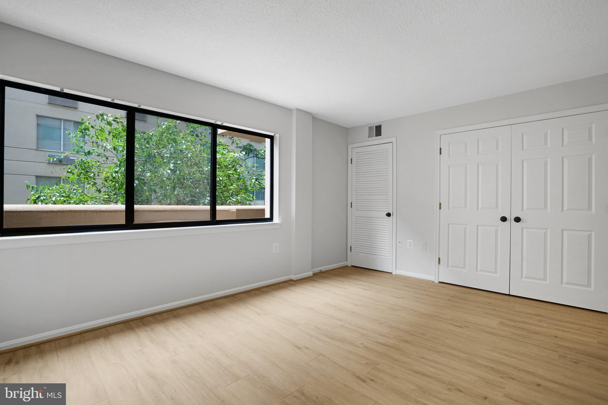 1301 North Courthouse Road, Unit 611 Arlington, VA 22201 - Photo 16 of 32 a view of an empty room with wooden floor and a window
