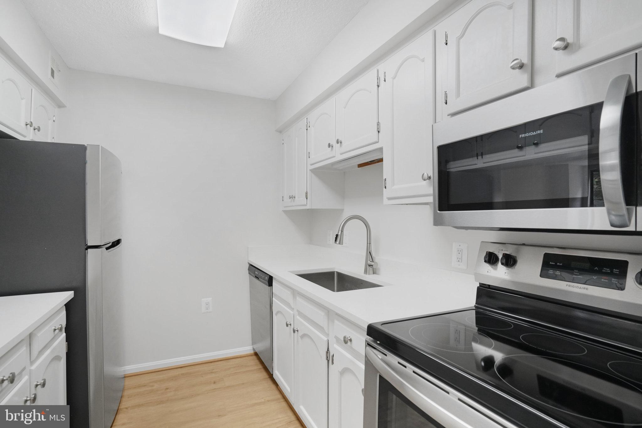1301 North Courthouse Road, Unit 611 Arlington, VA 22201 - Photo 9 of 32 a kitchen with white cabinets and stainless steel appliances