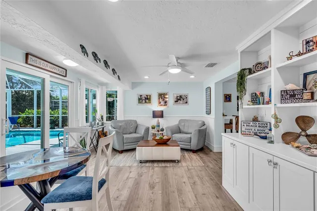 a spacious bedroom with a bed a dresser and painting on the wall