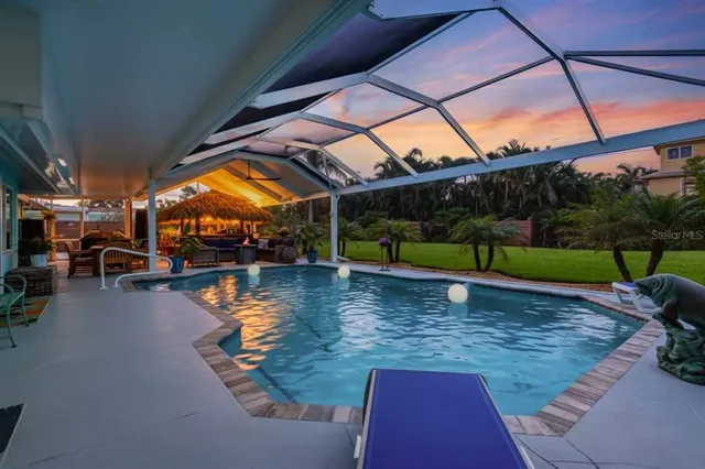 an aerial view of a house with swimming pool a yard and outdoor seating