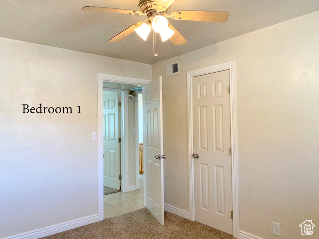 247 West 400 North, Unit 1 Moab, UT 84532 - Photo 13 of 27 Unfurnished bedroom featuring a ceiling fan, light colored carpet, and light tile patterned floors