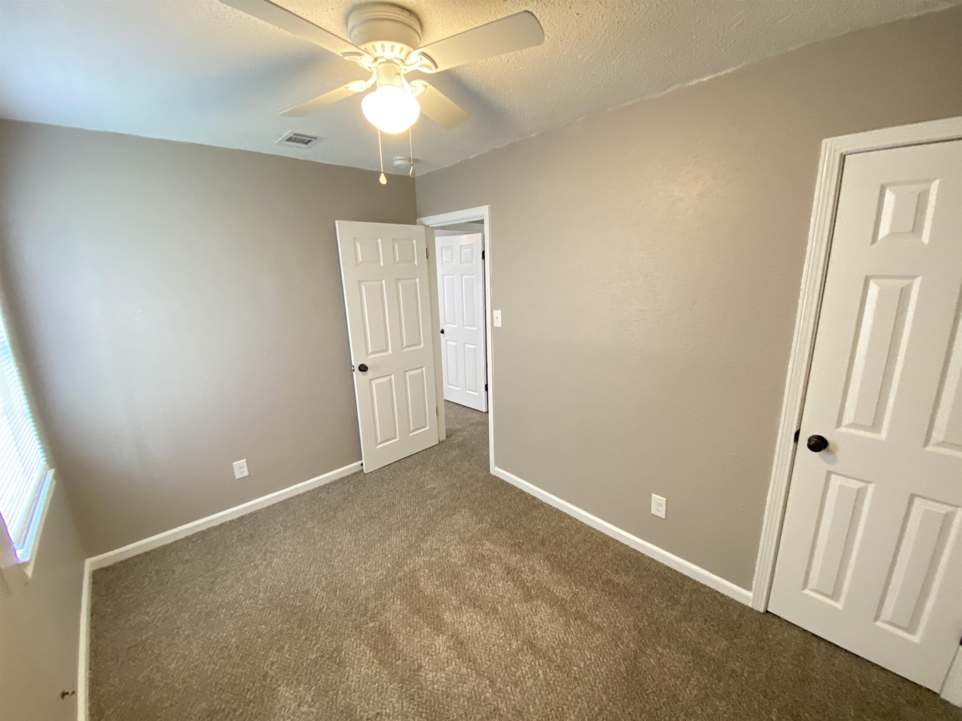 2581 Callie Road Memphis, TN 38127 - Photo 6 of 13 an empty room with a chandelier fan and windows