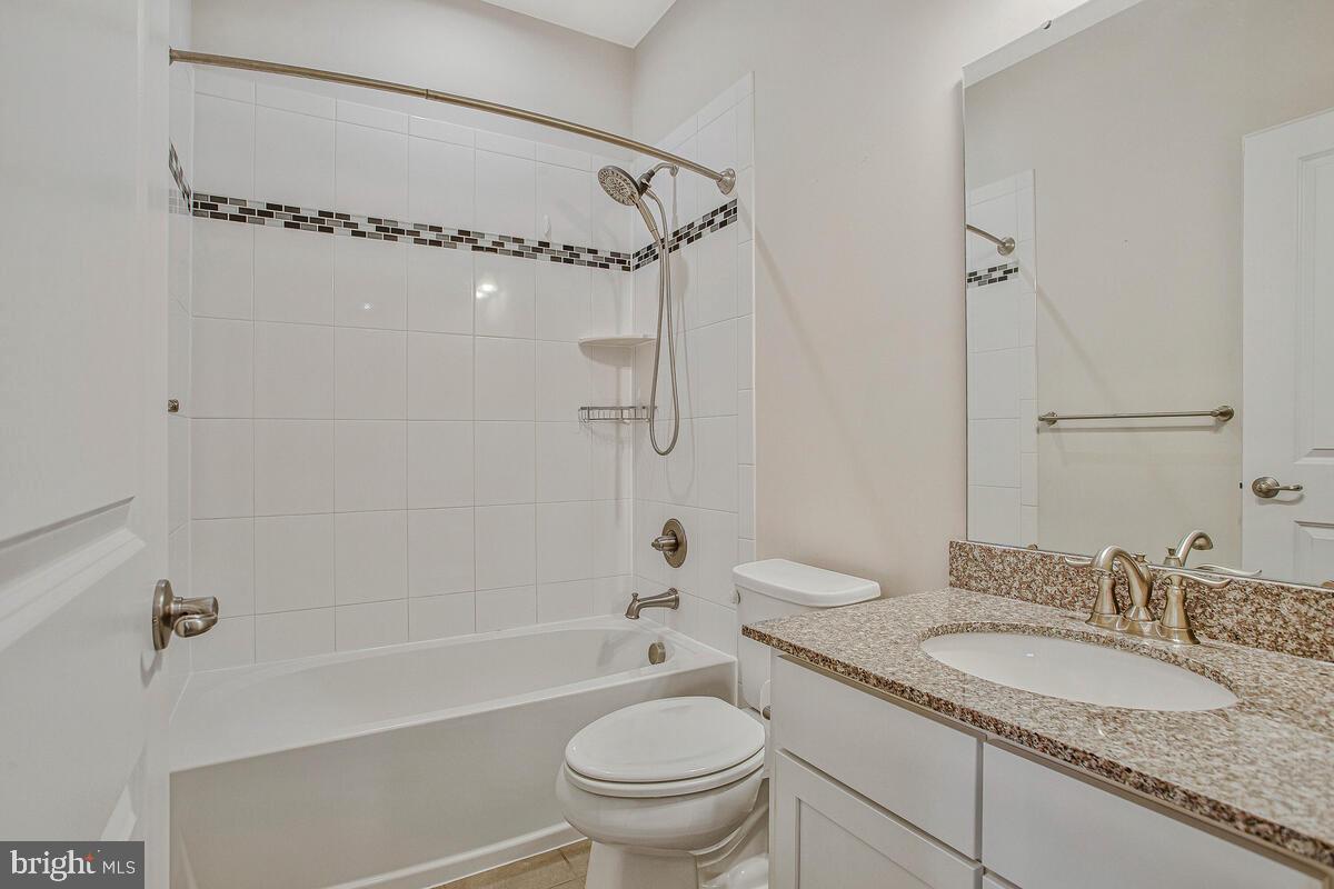 8218 Kippis Road Millersville, MD 21108 - Photo 27 of 40 a bathroom with a granite countertop sink a toilet and shower