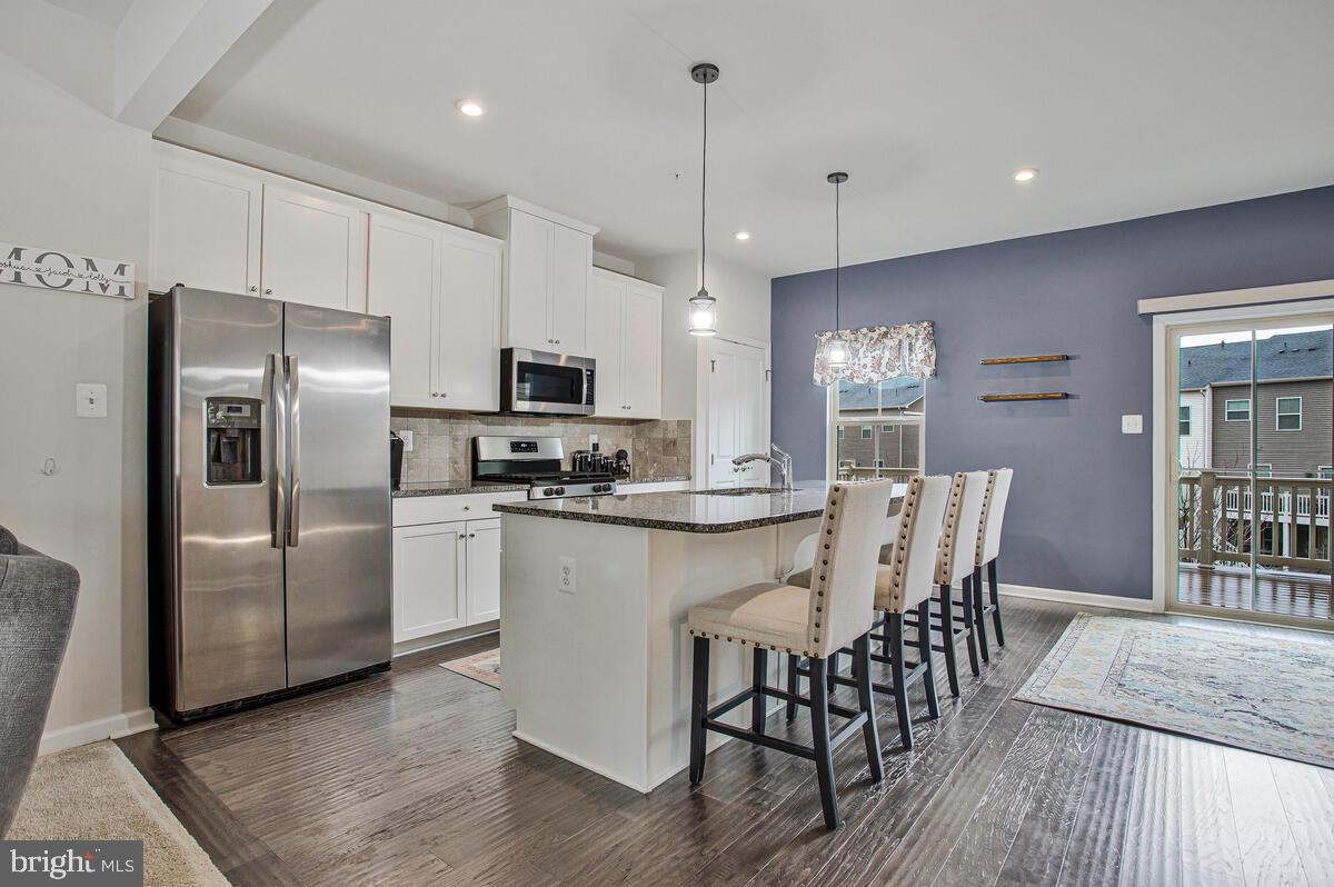 8218 Kippis Road Millersville, MD 21108 - Photo 6 of 40 a kitchen with stainless steel appliances a refrigerator a stove a sink a dining table and chairs