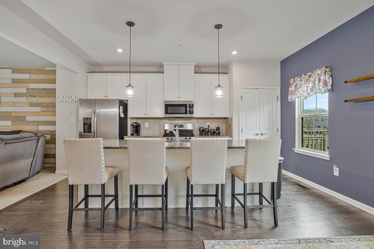 8218 Kippis Road Millersville, MD 21108 - Photo 7 of 40 a large kitchen with dining table chairs and refrigerator