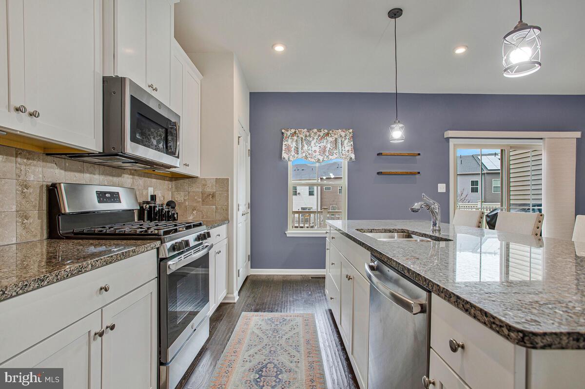 8218 Kippis Road Millersville, MD 21108 - Photo 9 of 40 a kitchen with stainless steel appliances granite countertop a stove a sink and a microwave