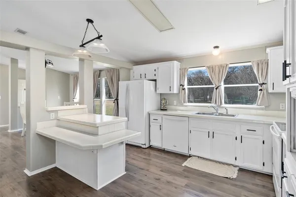 a kitchen with granite countertop a sink and white cabinets