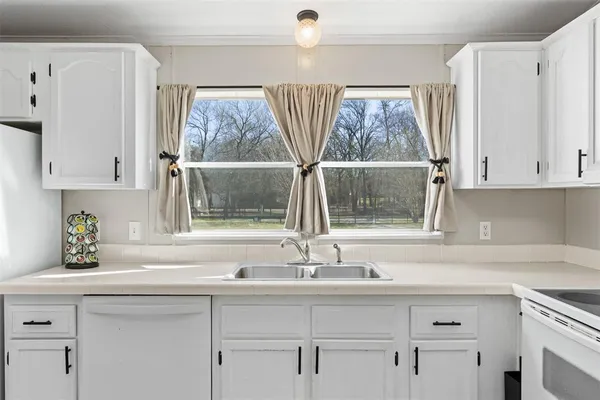 a sink with a window and cabinets