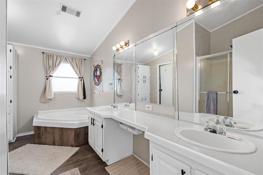 181 Pr 125 Whitney, TX 76692 - Photo 16 of 34 a bathroom with a double vanity sink a mirror and a bathtub