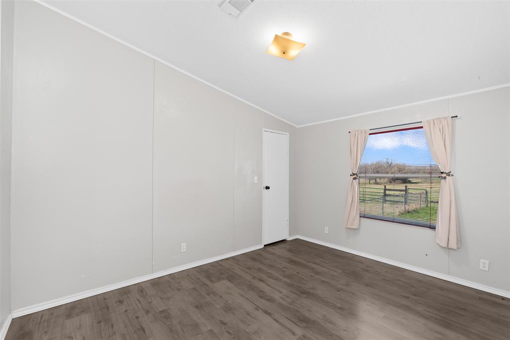 181 Pr 125 Whitney, TX 76692 - Photo 19 of 34 an empty room with windows and wooden door