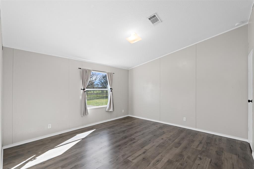 181 Pr 125 Whitney, TX 76692 - Photo 20 of 34 an empty room with wooden floor and windows