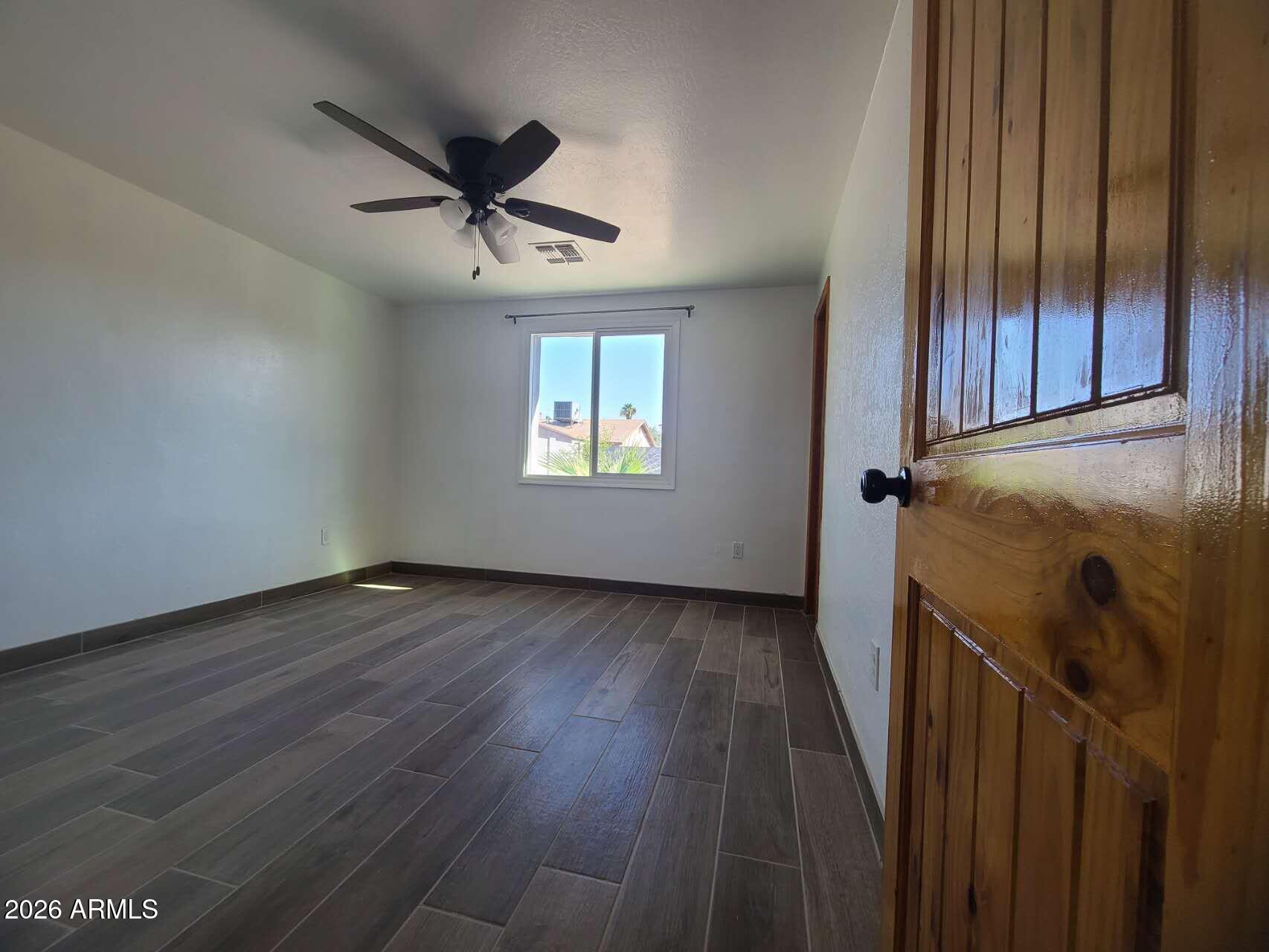 3702 East Thunderbird Road Phoenix, AZ 85032 - Photo 16 of 23 an empty room with wooden floor closet and windows