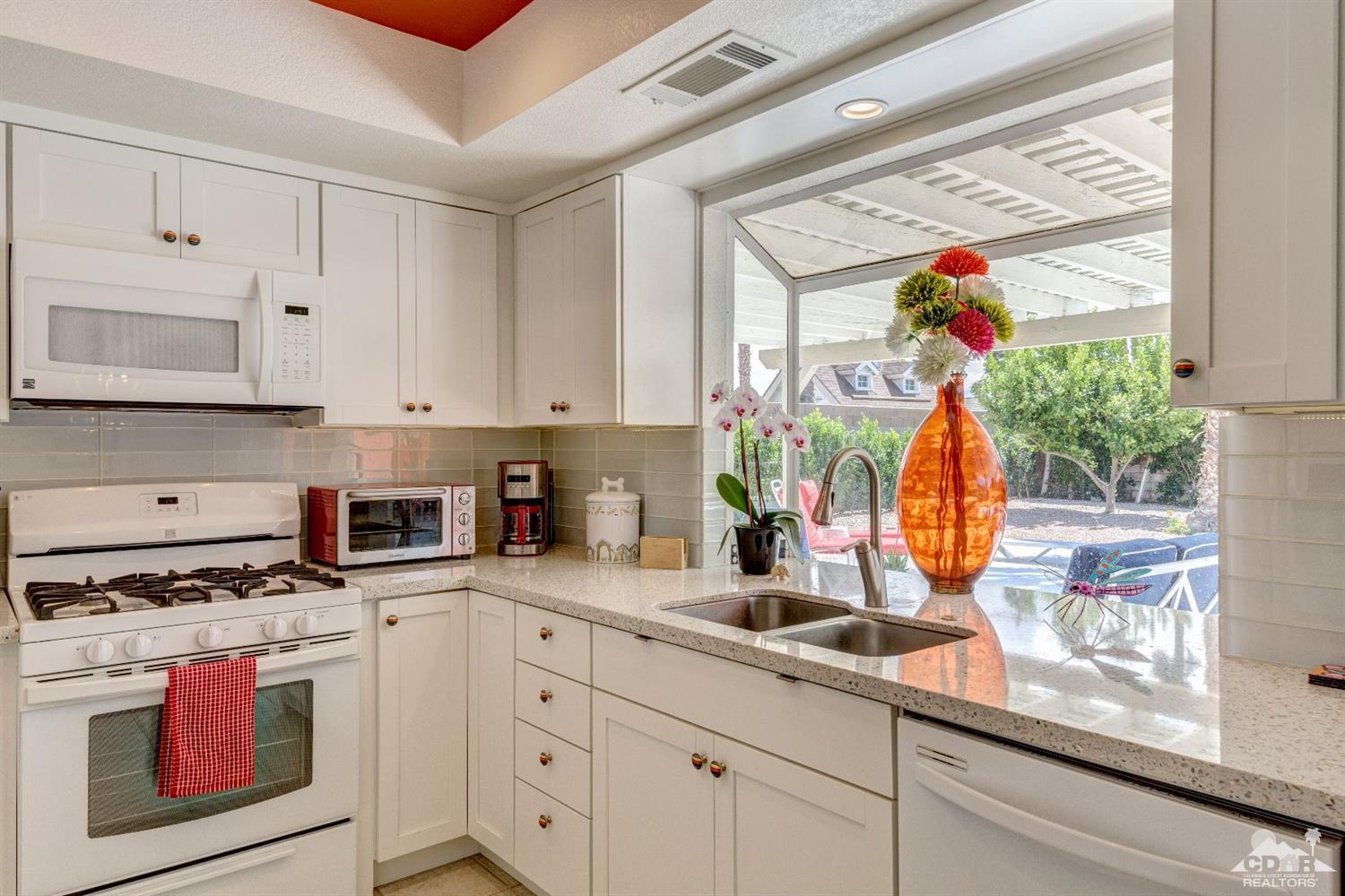 68365 Encinitas Road Cathedral City, CA 92234 - Photo 14 of 25 a kitchen with stainless steel appliances granite countertop a stove a sink and a microwave