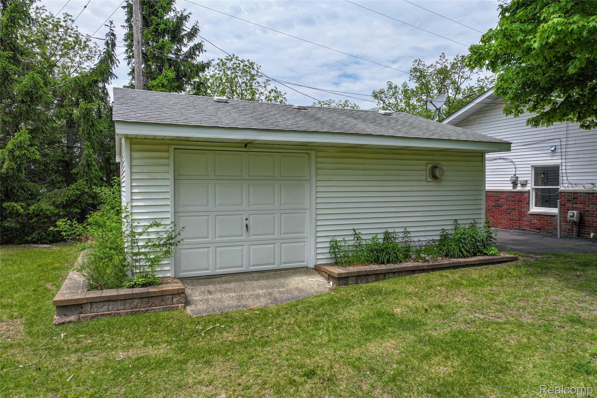422 East Road Holly, MI 48442 - Photo 13 of 51 Detached garage featuring a paneled door, horizontal siding, and a shingle roof
