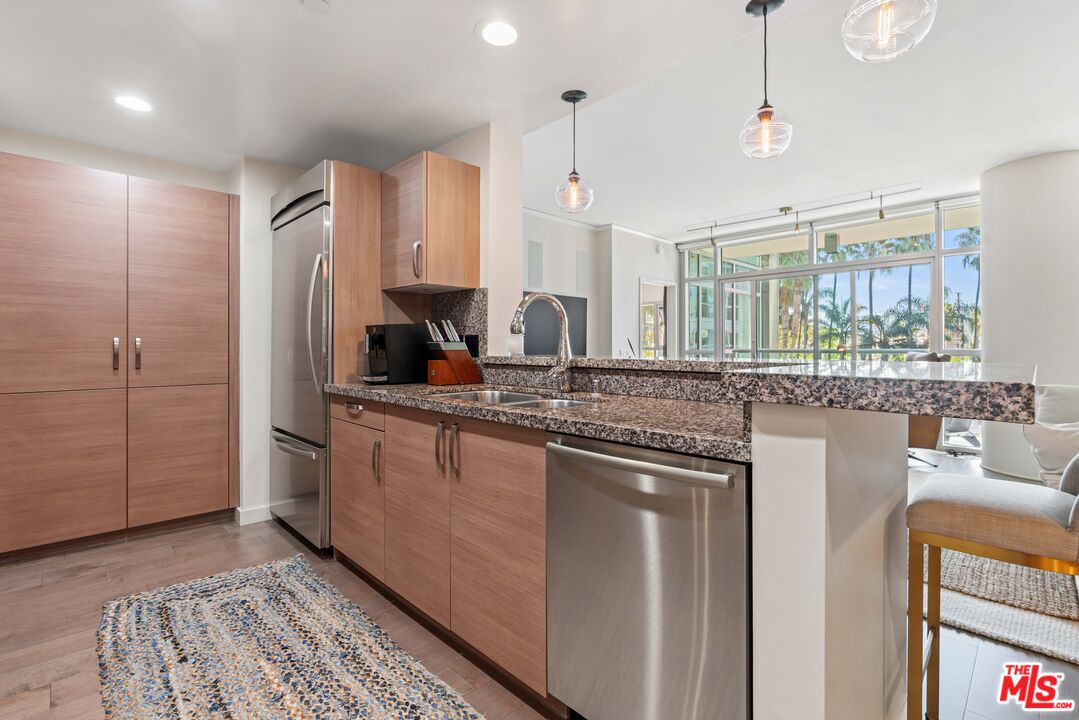 13650 Marina Pointe Drive, Unit 309 Marina del Rey, CA 90292 - Photo 20 of 56 a kitchen with stainless steel appliances granite countertop a sink a stove and a refrigerator
