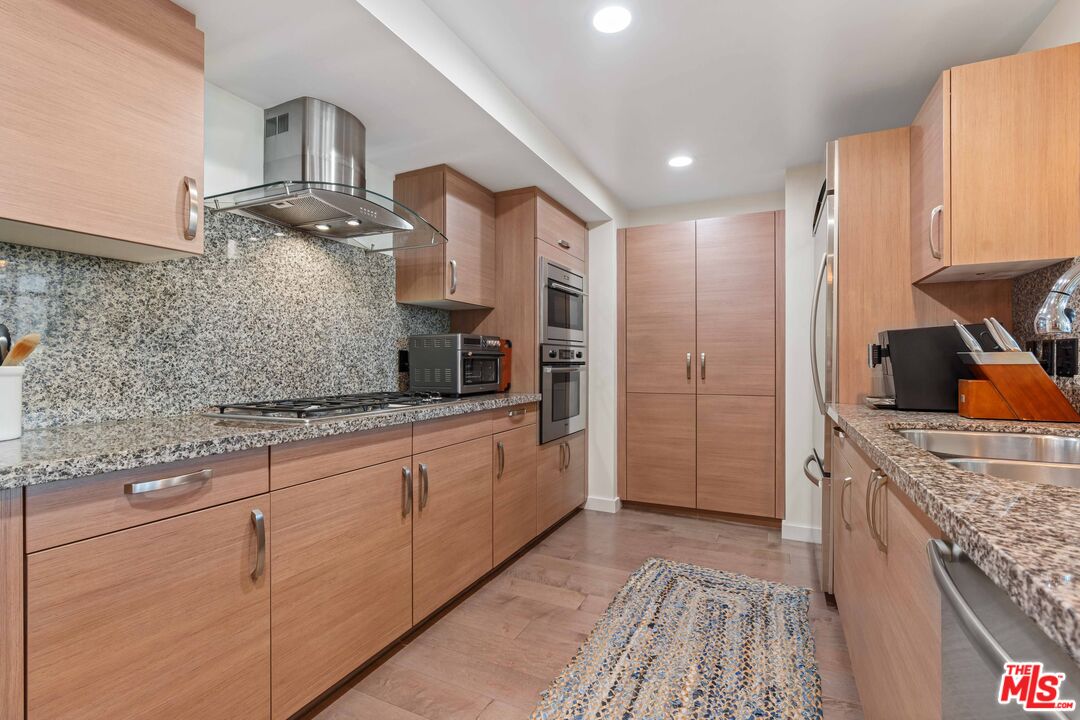 13650 Marina Pointe Drive, Unit 309 Marina del Rey, CA 90292 - Photo 21 of 56 a large kitchen with kitchen island granite countertop a sink and cabinets