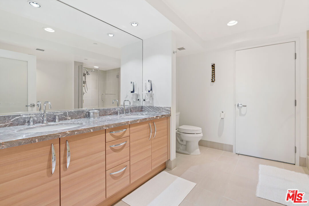 13650 Marina Pointe Drive, Unit 309 Marina del Rey, CA 90292 - Photo 8 of 56 a bathroom with a granite countertop sink a toilet and a shower