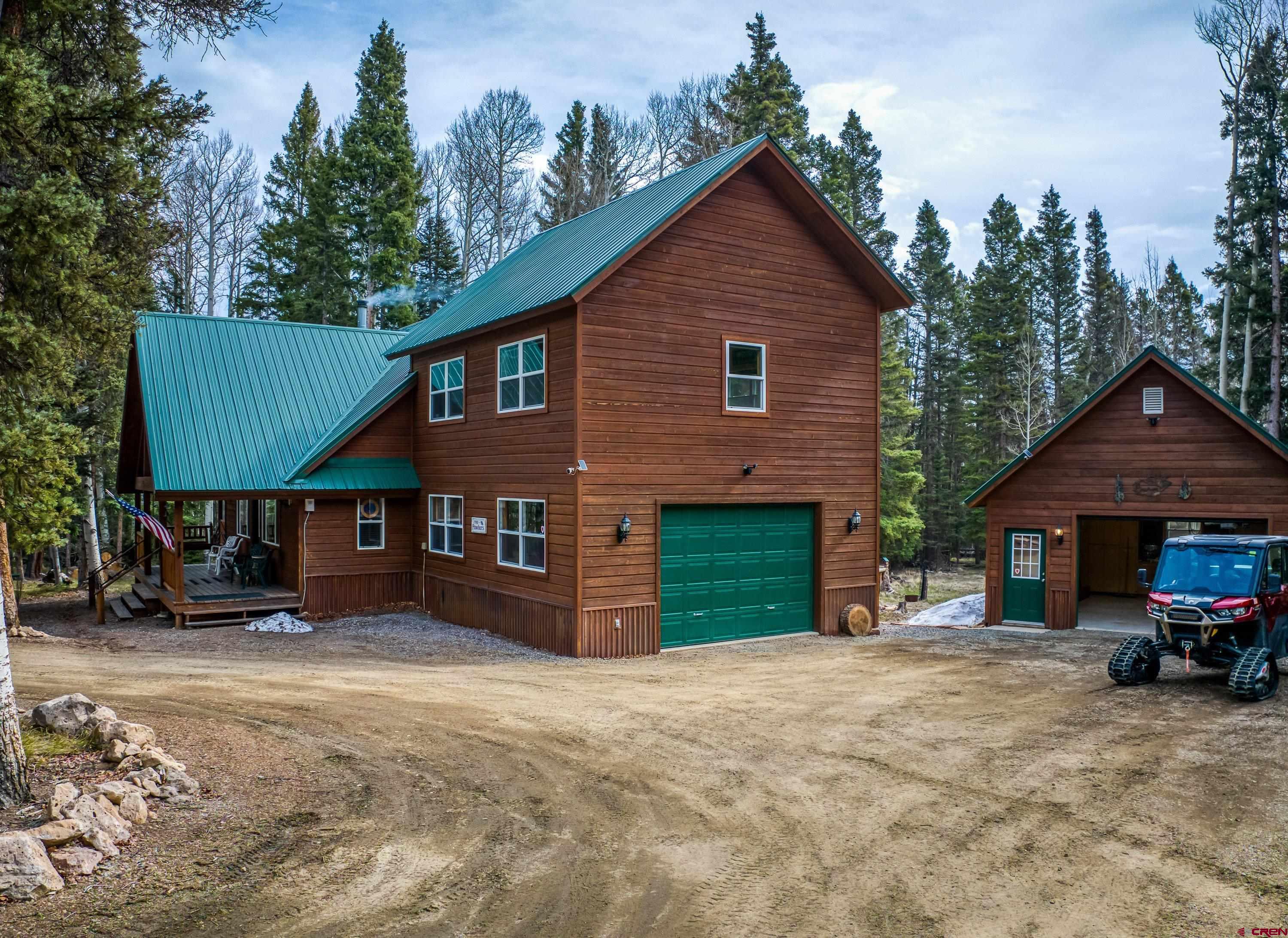 200 Lake Road Cimarron, CO 81220 - Photo 1 of 45 a front view of a house with a yard and garage