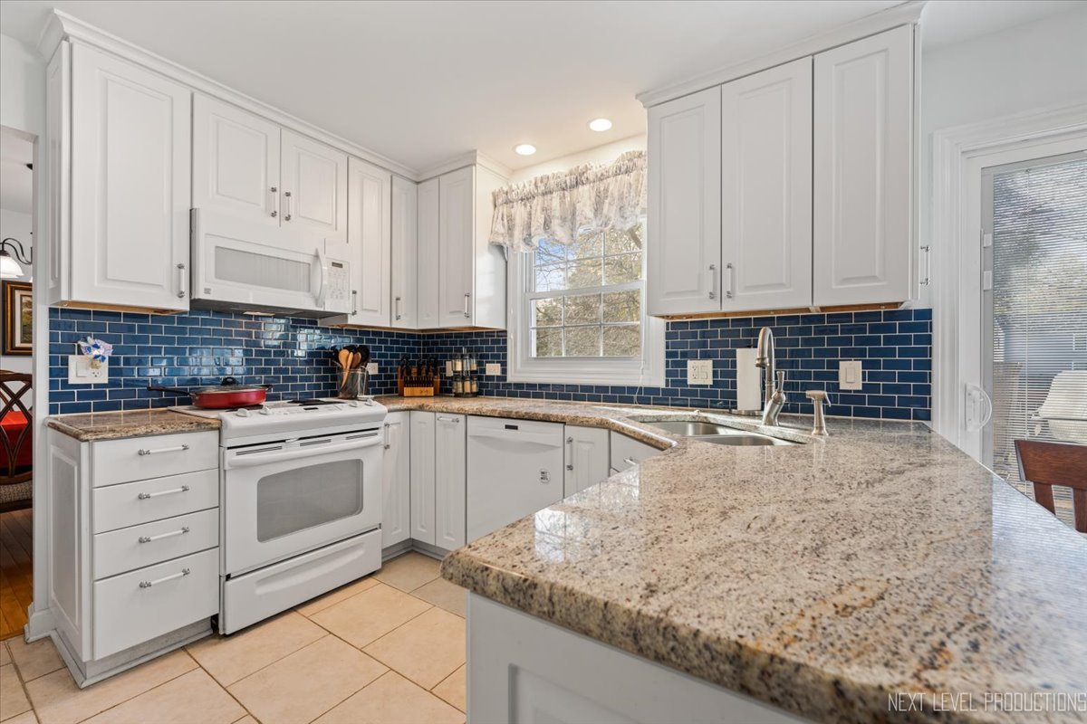 2167 Countryside Circle Naperville, IL 60565 - Photo 2 of 27 a kitchen with granite countertop white cabinets and white appliances