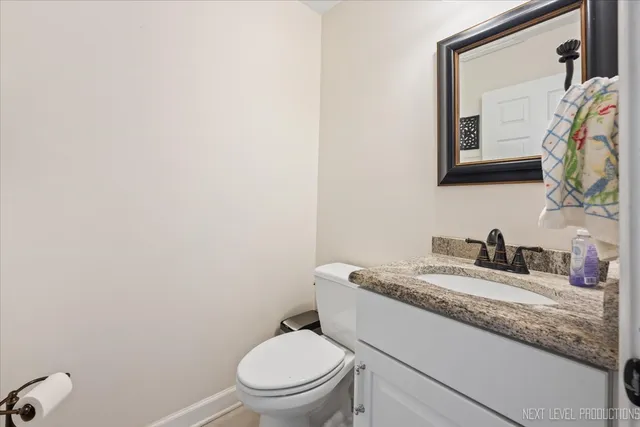 a bathroom with a granite countertop toilet sink and mirror