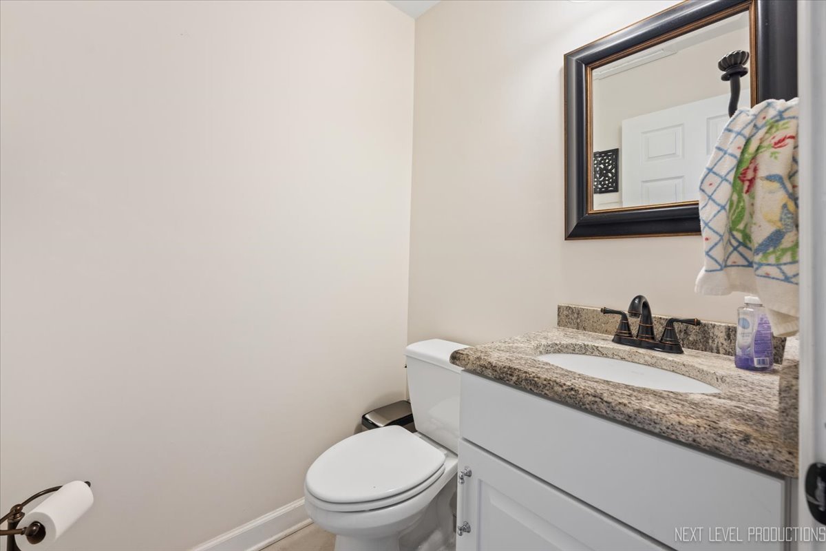 2167 Countryside Circle Naperville, IL 60565 - Photo 9 of 27 a bathroom with a granite countertop toilet sink and mirror