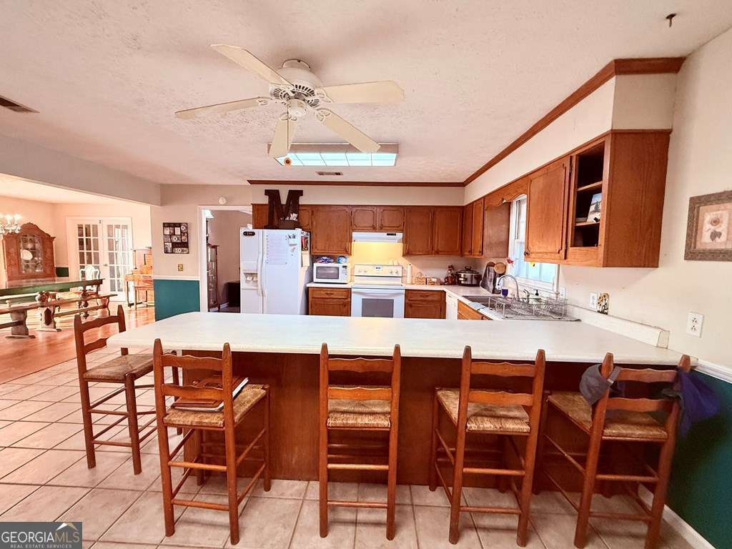 1881 Bell Telephone Road Hazlehurst, GA 31539 - Photo 20 of 71 a kitchen with a dining table chairs and white cabinets