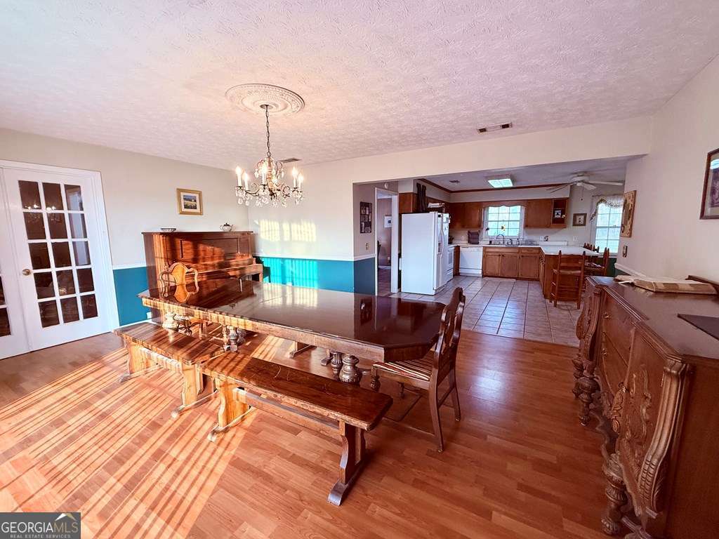 1881 Bell Telephone Road Hazlehurst, GA 31539 - Photo 23 of 71 a living room with furniture a chandelier and wooden floor