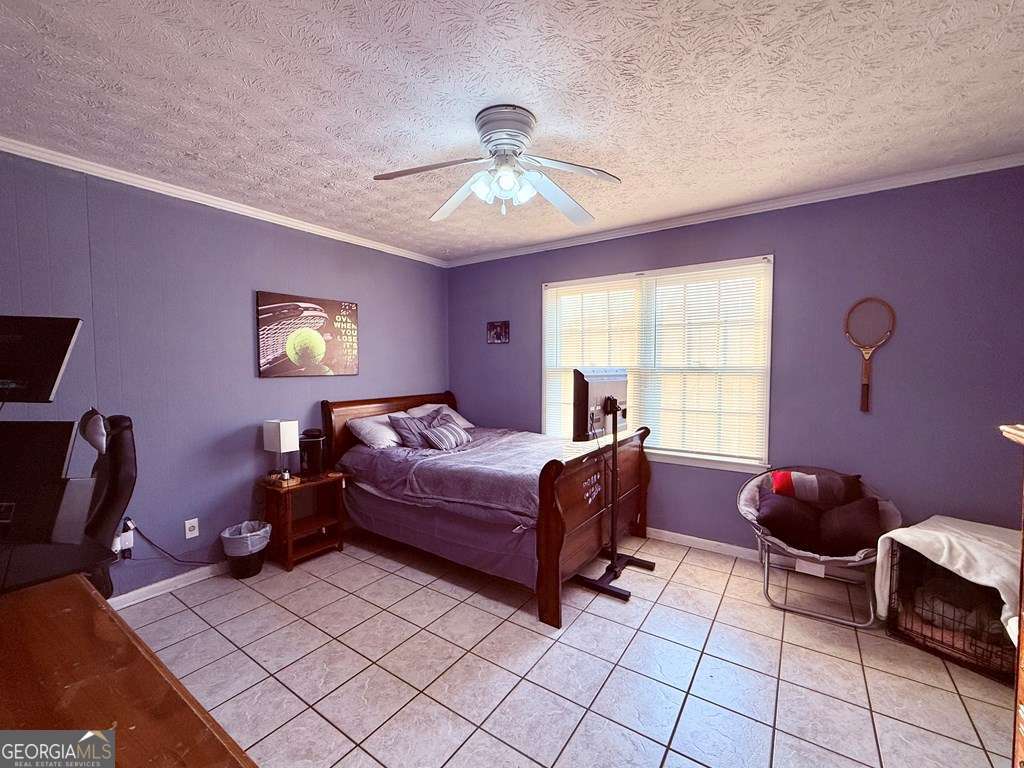 1881 Bell Telephone Road Hazlehurst, GA 31539 - Photo 34 of 71 a spacious bedroom with a bed and a chandelier