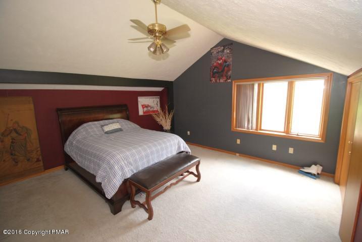 154 Bowman Road Mount Pocono, PA 18344 - Photo 29 of 41 a spacious bedroom with a bed and a chandelier
