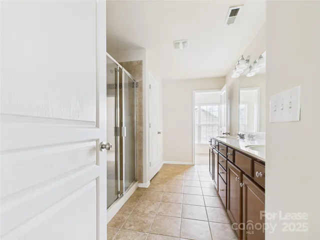 a bathroom with a double vanity sink a mirror and a shower
