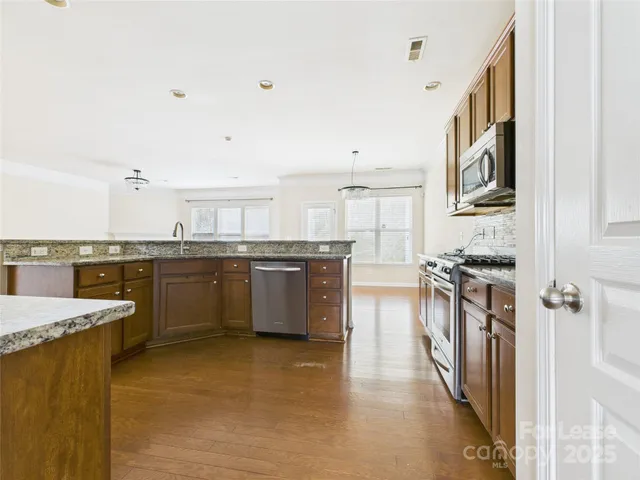 a kitchen with stainless steel appliances granite countertop a stove cabinets and a refrigerator