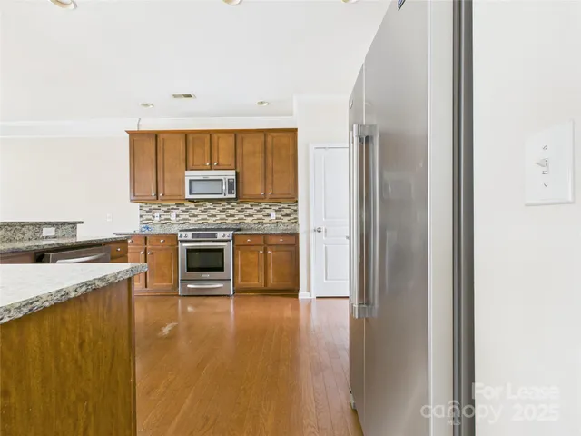 a kitchen with a stove top oven and refrigerator