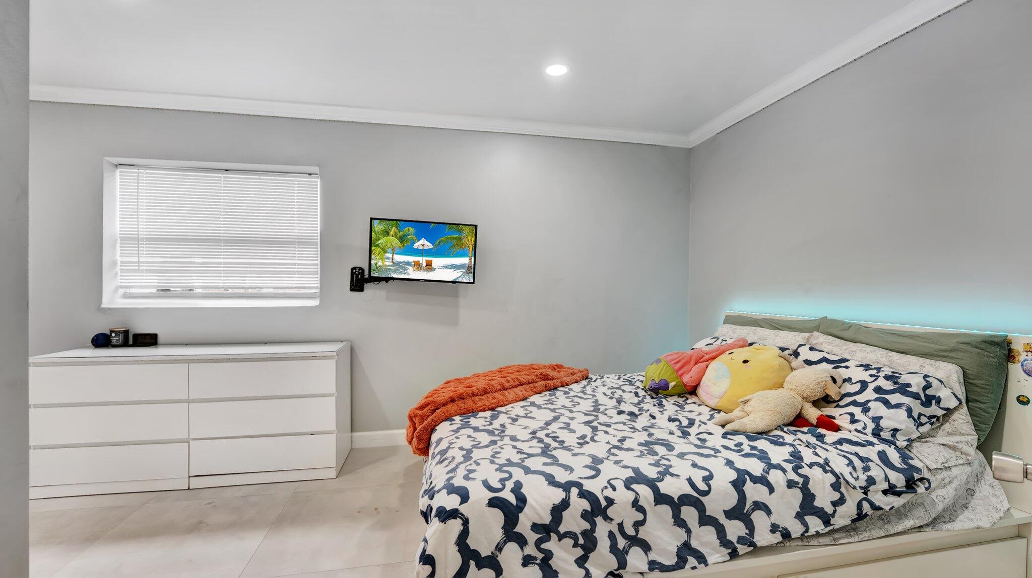 9709 Southwest 1st Place Boca Raton, FL 33428 - Photo 11 of 32 a bedroom with a bed and a window