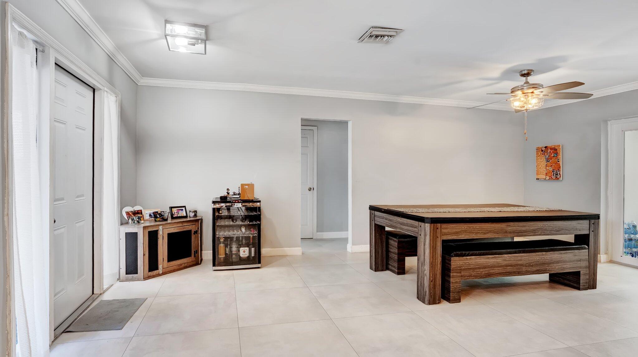 9709 Southwest 1st Place Boca Raton, FL 33428 - Photo 5 of 32 a view of a workspace with furniture and a ceiling fan