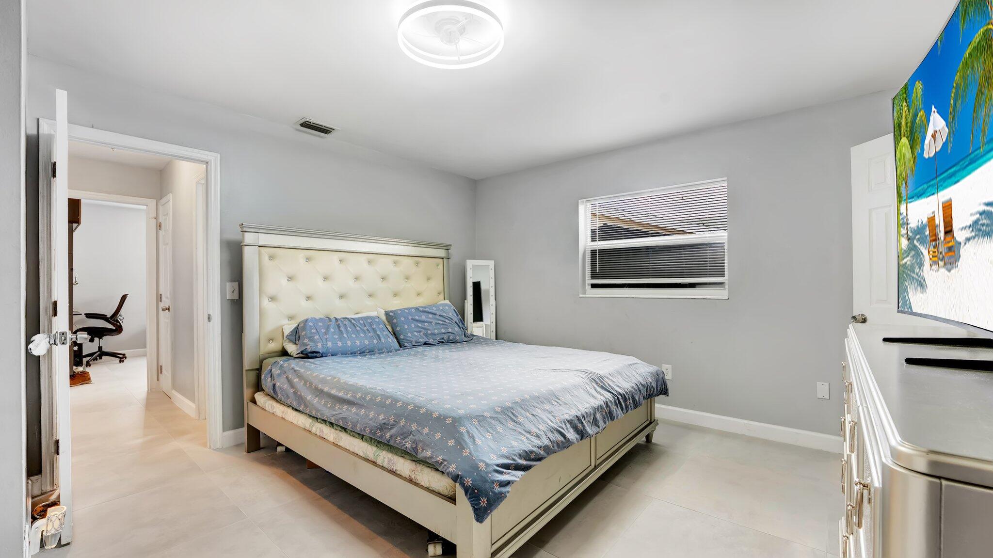 9709 Southwest 1st Place Boca Raton, FL 33428 - Photo 9 of 32 a bedroom with a bed and painting on the wall