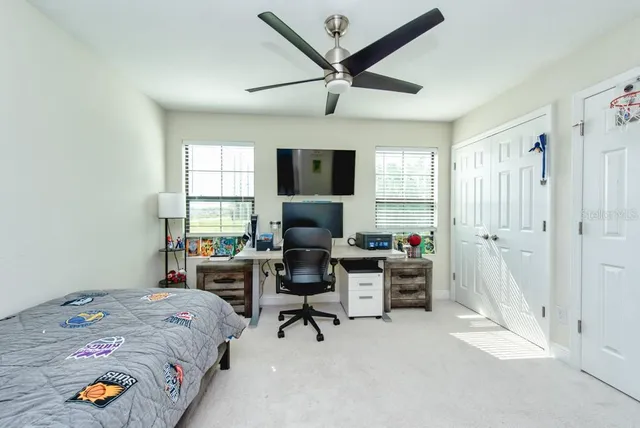 a bed room with a bed and a ceiling fan