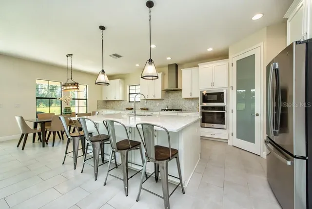 a dining room with furniture and kitchen view