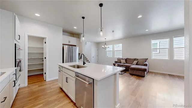 a open kitchen with stainless steel appliances granite countertop a sink stove and wooden floor