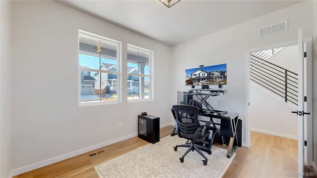 a view of a workspace with furniture and wooden floor