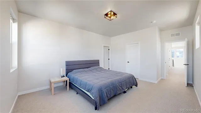 a bedroom with a bed and painting on the wall