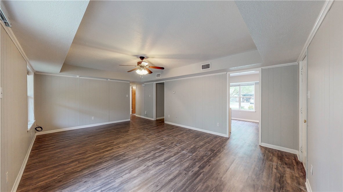 1108 Forest Glen Court Bryan, TX 77803 - Photo 13 of 26 an empty room with wooden floor chandelier fan and windows