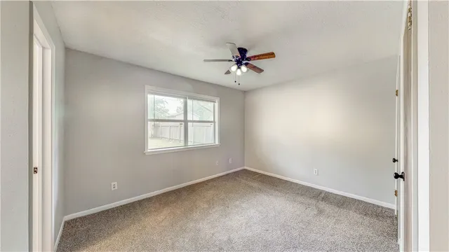 a view of a room with a ceiling fan and a window