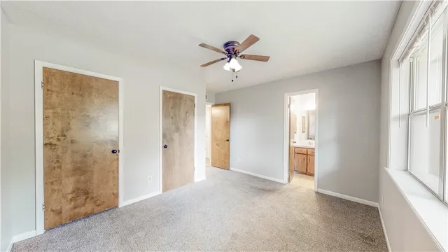 a view of a livingroom with a chandelier fan and windows