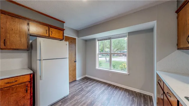 a view of kitchen with a refrigerator cabinets and wooden floor