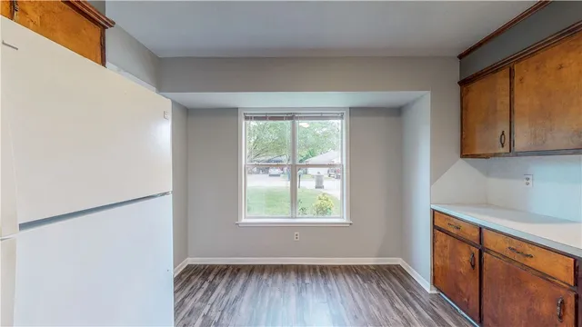 a view of a kitchen with wooden floor and a window