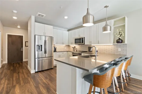 a kitchen with refrigerator cabinets and wooden floor