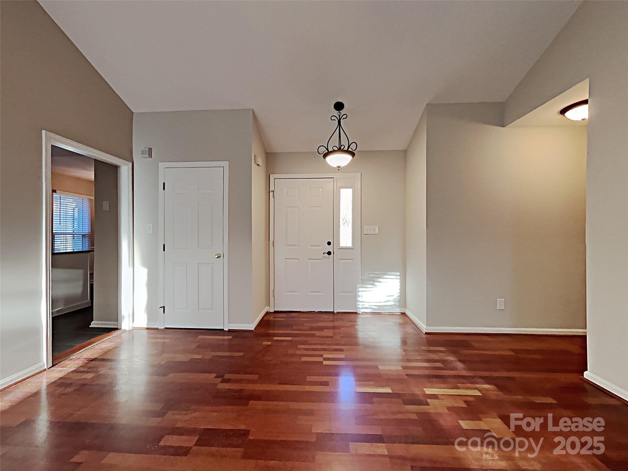 10715 Spruce Mountain Road Charlotte, NC 28214 - Photo 16 of 26 a view of an empty room with wooden floor and a window