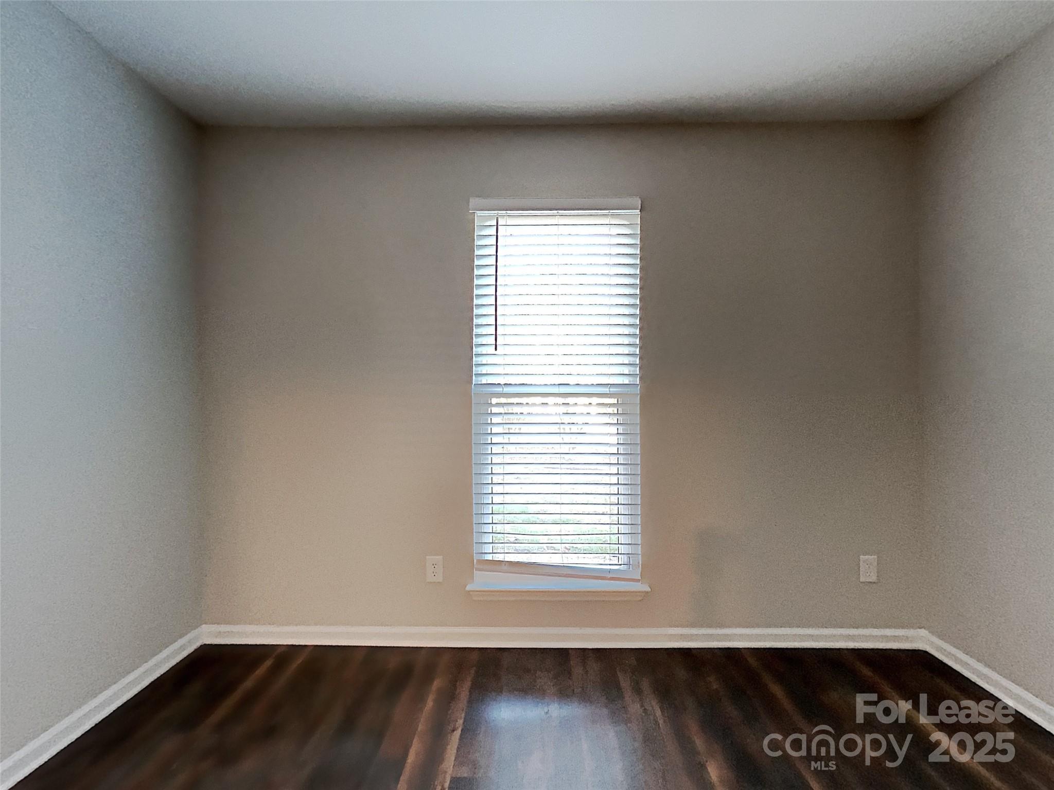 10715 Spruce Mountain Road Charlotte, NC 28214 - Photo 20 of 26 a view of an empty room with wooden floor and a window