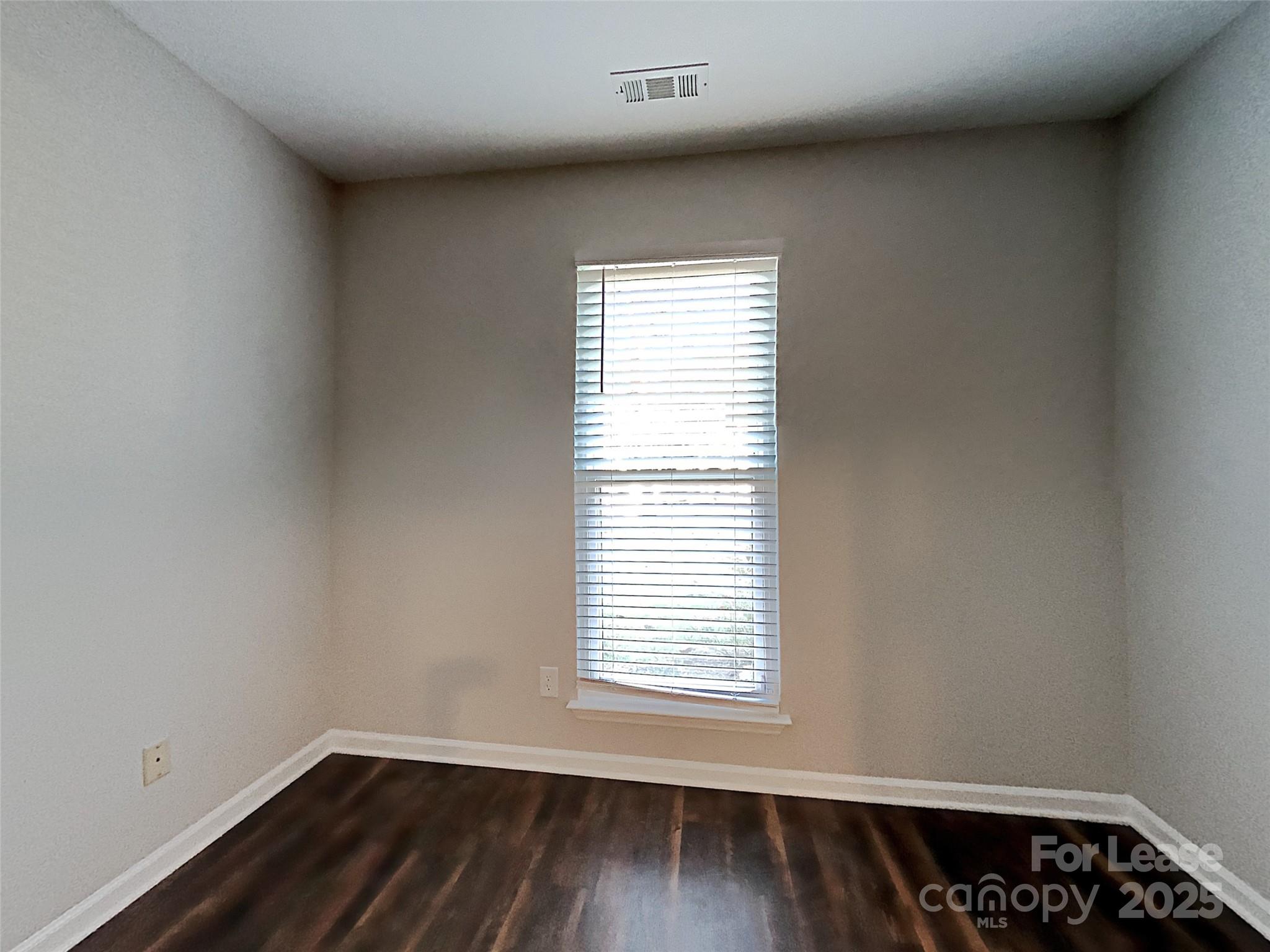 10715 Spruce Mountain Road Charlotte, NC 28214 - Photo 21 of 26 a view of an empty room with wooden floor and a window